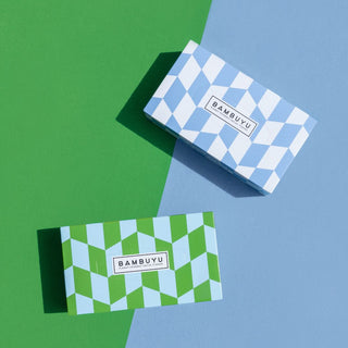 Green and light blue rectangular tissue boxes placed behind contrast color background.